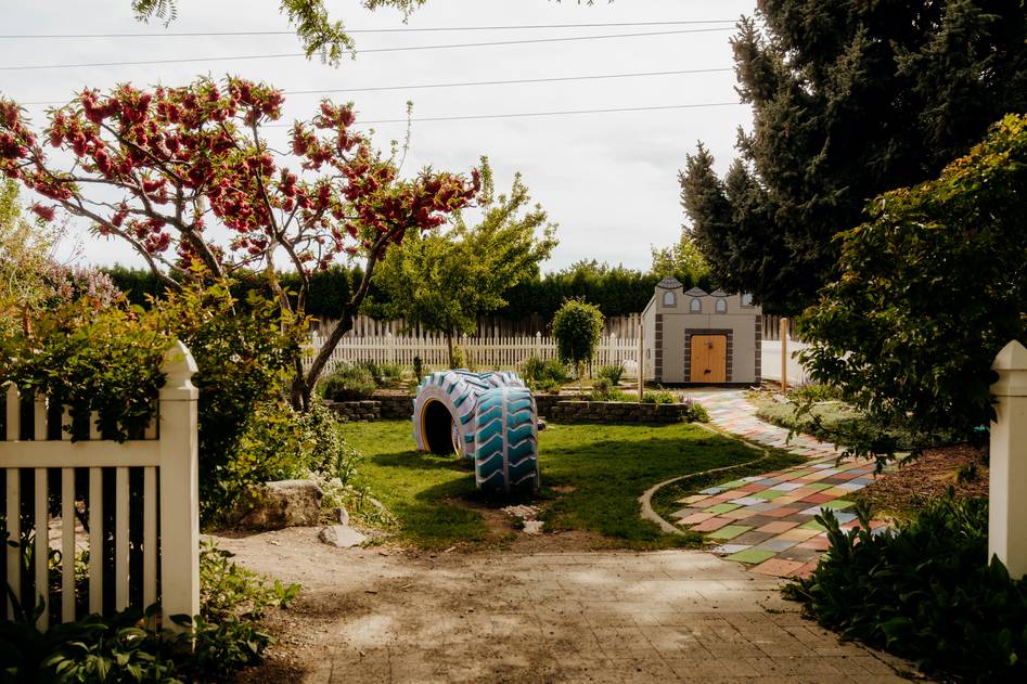 Cozy garden swing surrounded by blooming flowers and greenery
