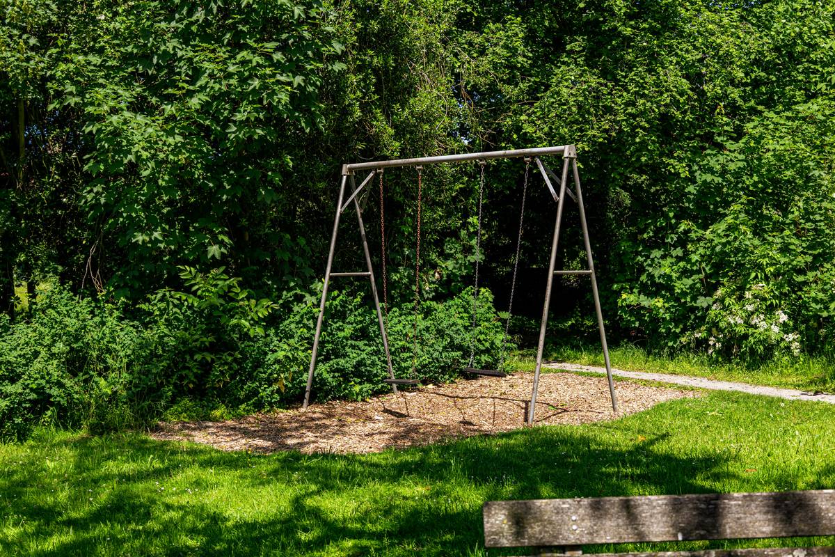 Close-up of a high-quality outdoor metal swing set showing thick frame tubing and welded joints